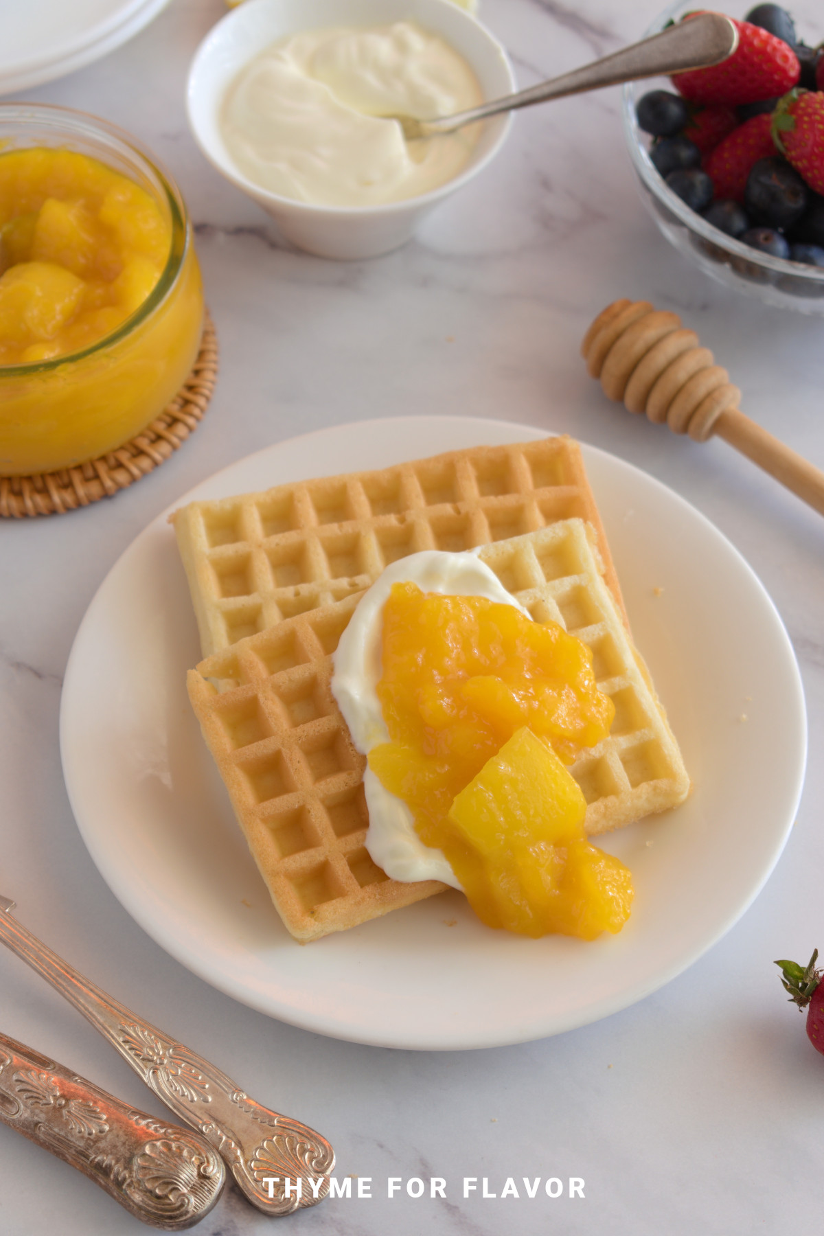 Waffles topped with cream and mango compote.