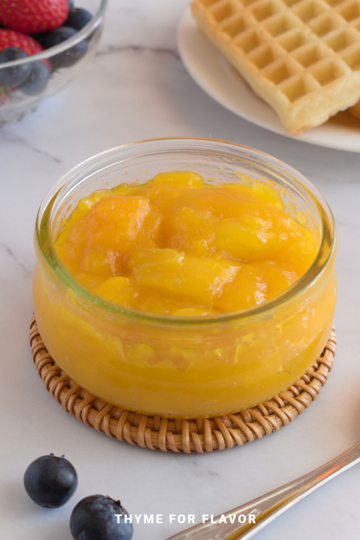 Mango compote in a round glass container.