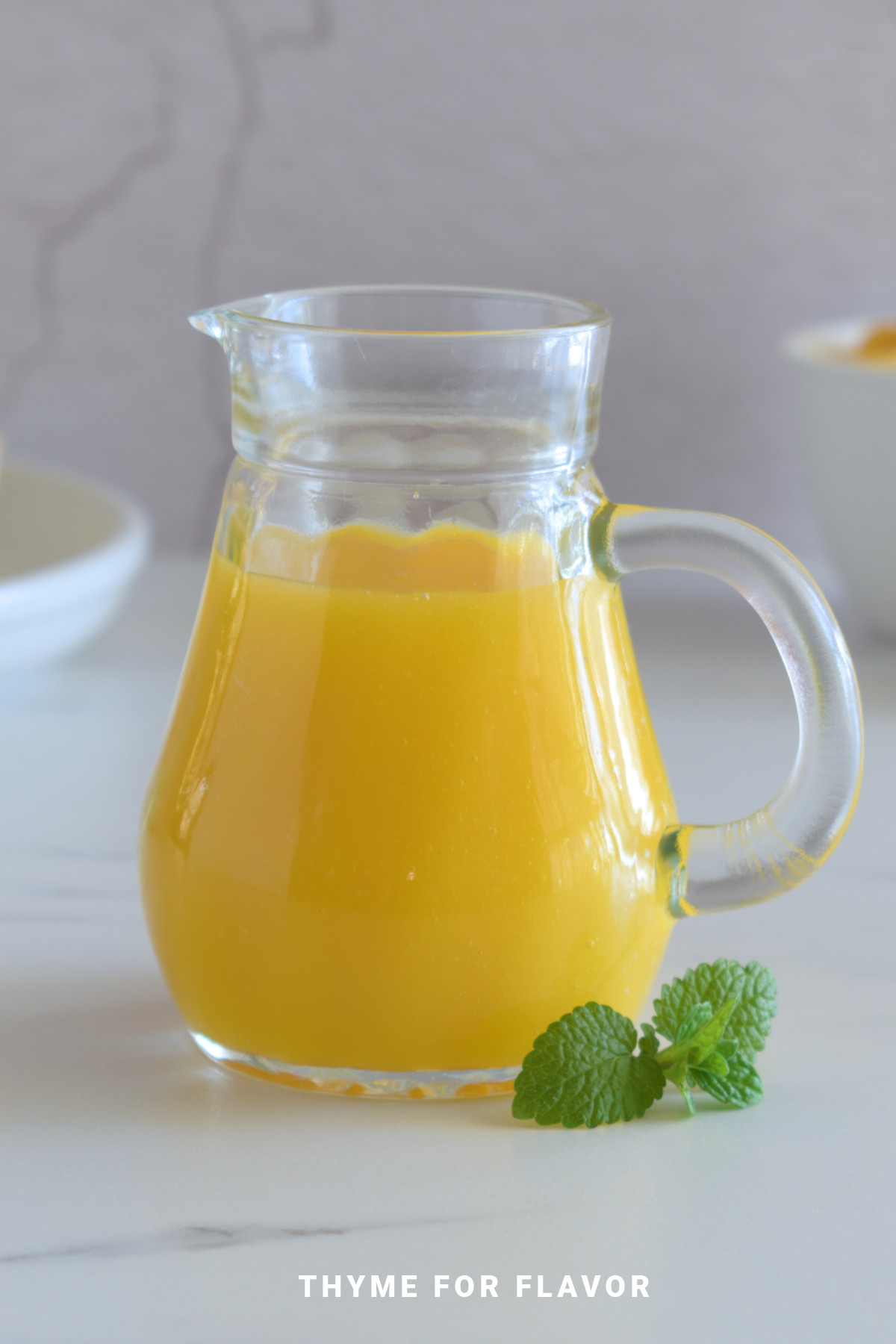 Mango coulis in a glass jug.