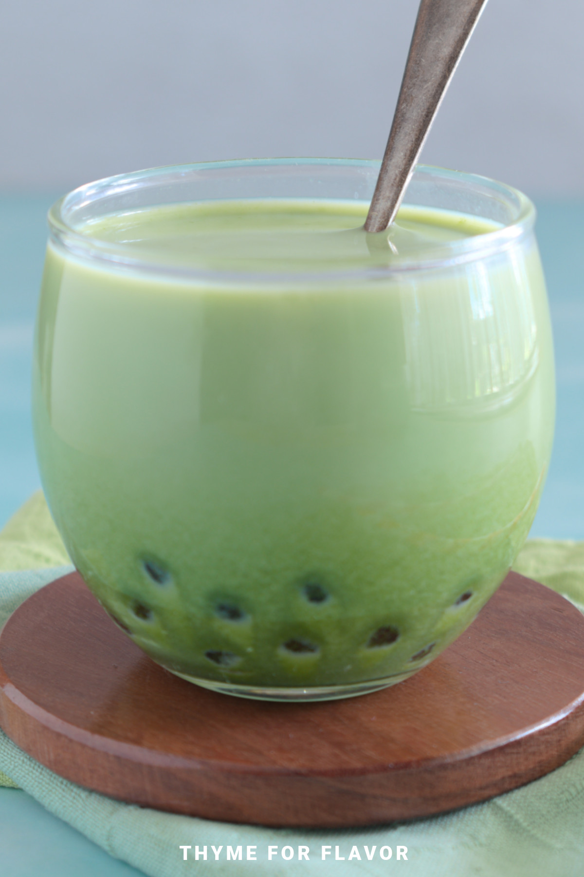 Close up image of matcha milk tea in a glass.