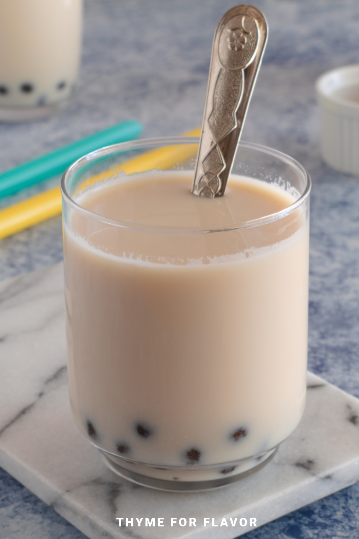 A glass of caramel milk tea with tapioca pearls.