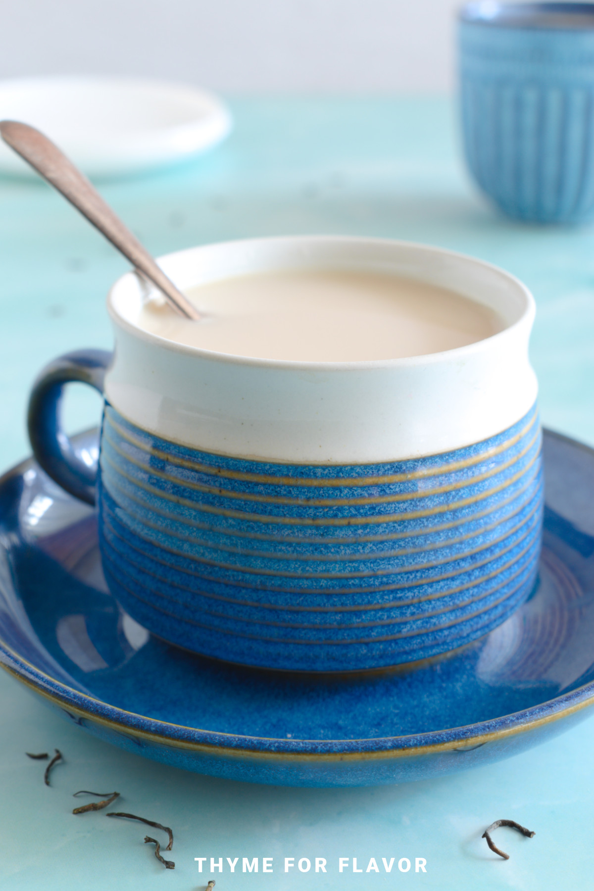 Assam tea with milk in a blue mug on a blue saucer.
