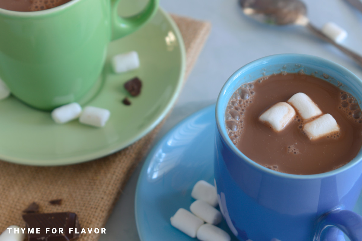 Oat milk hot chocolates in a blue mug and a green mug.