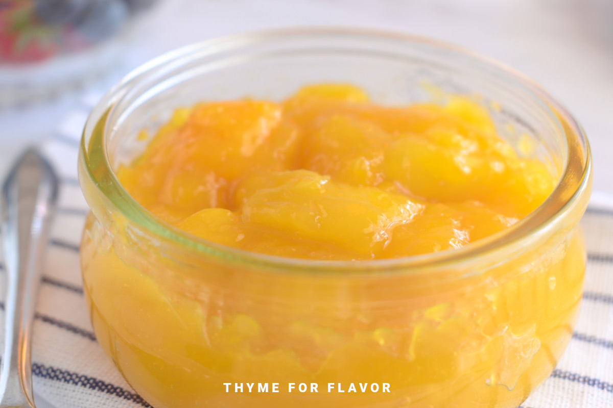 Close up image of mango compote in a glass container.