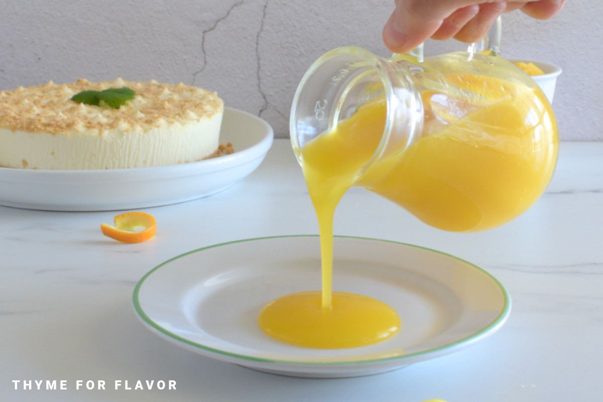 Pouring mango coulis into a white plate.