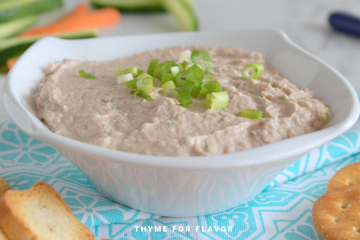 Tuna dip with spring onions in a square bowl.