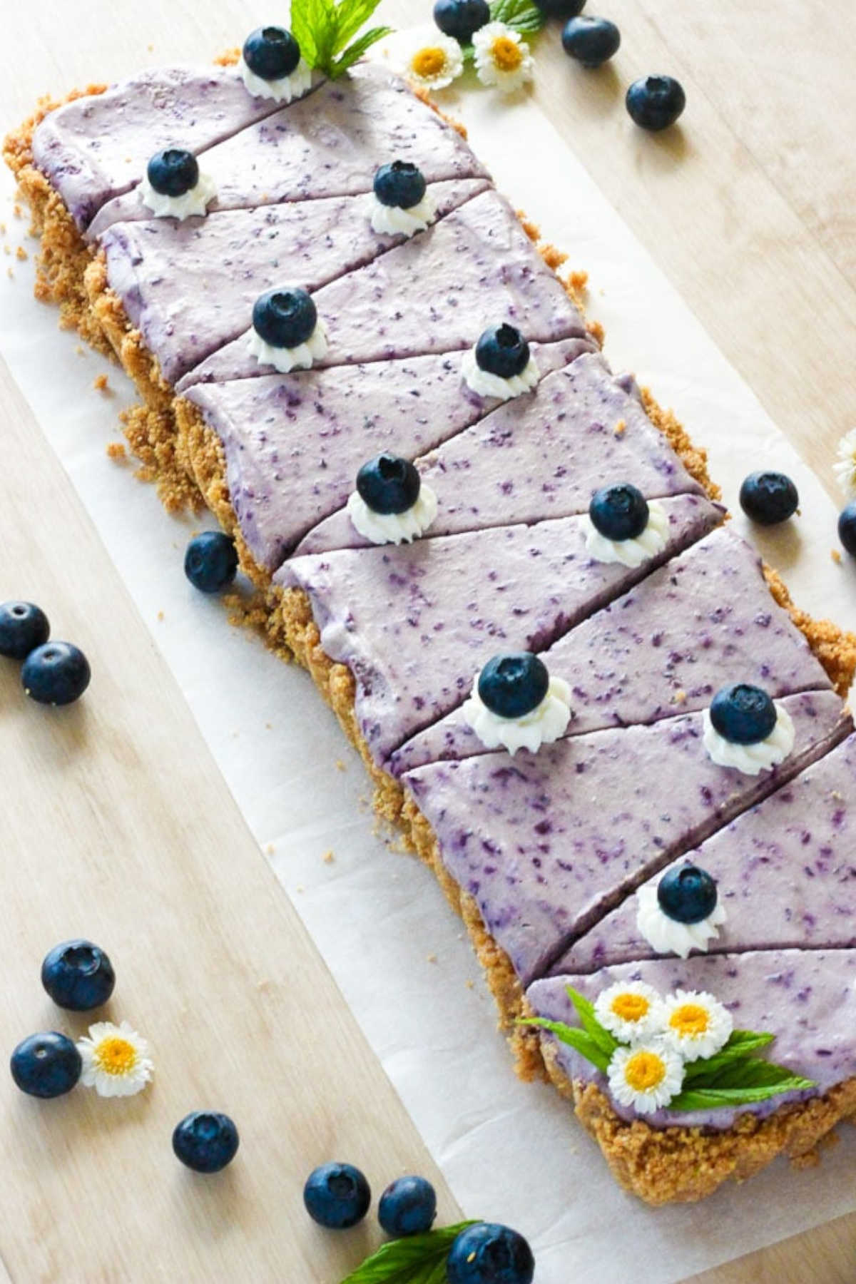 No bake blueberry cheesecake with blueberry icing on top and fresh blueberries.