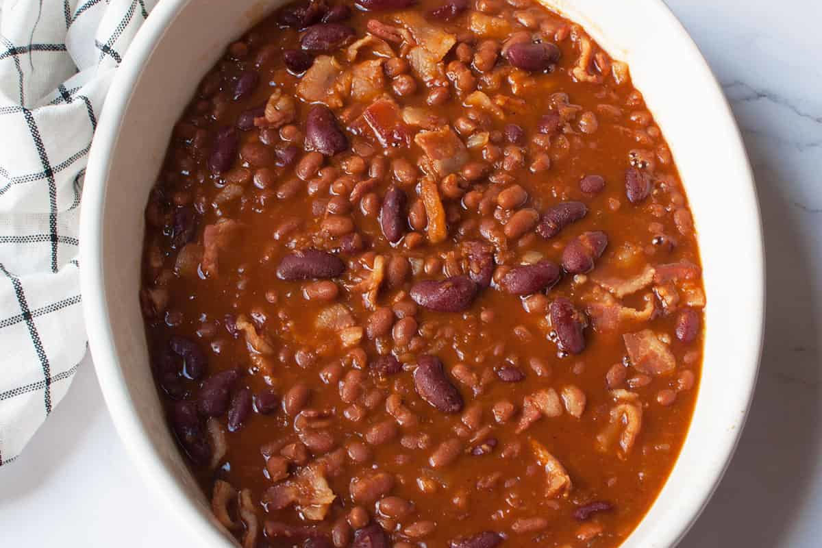 Baked beans in a large white bowl.