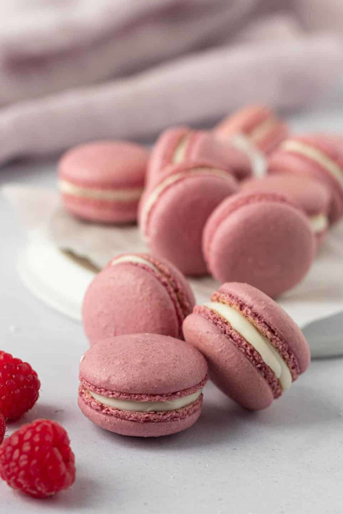 Raspberry macarons on a benchtop.