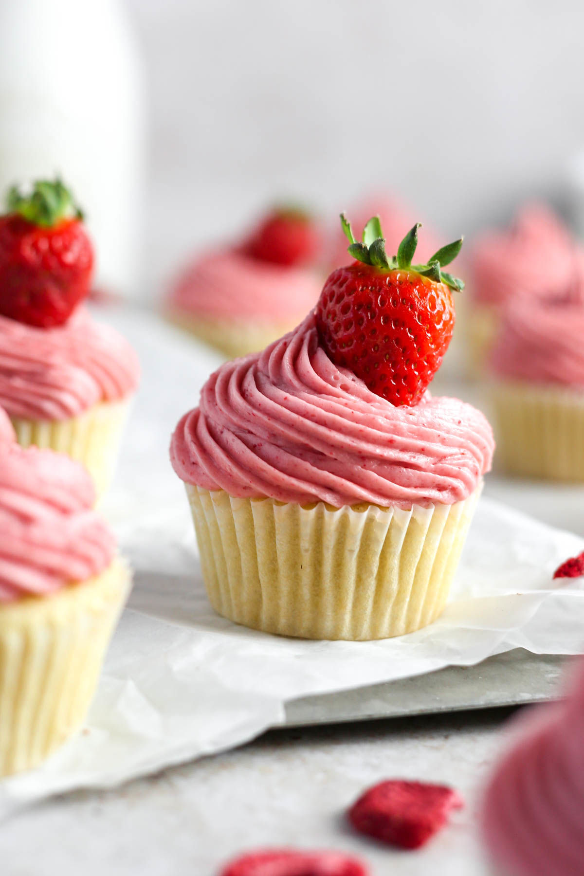 Close up image of strawberry cupcakes on parchment paper.
