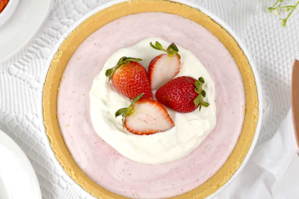 Close up image of strawberry pie in a white dish.