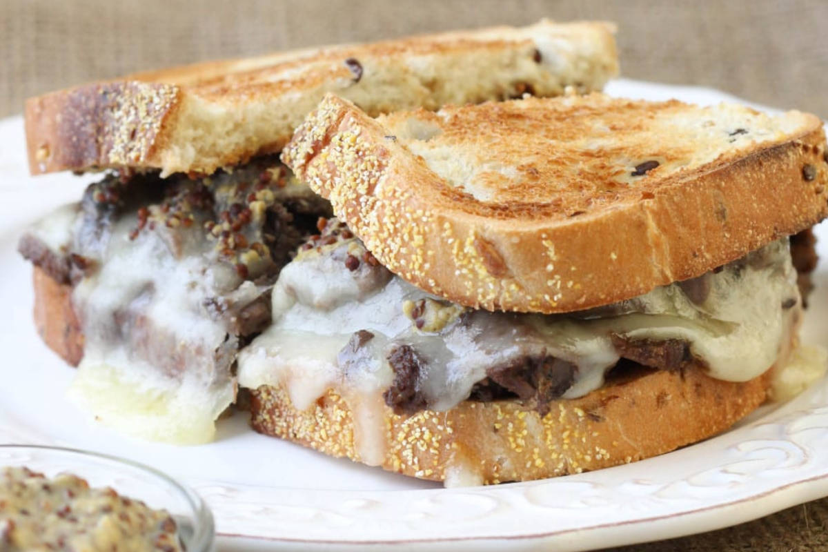 Close up image of shaved beef sandwich melt on a plate.