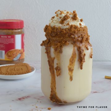 Close up image of biscoff milkshake in a glass.