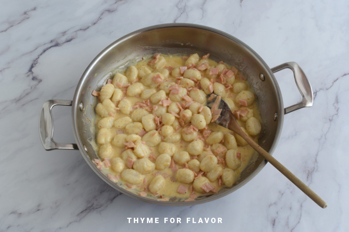 Gnocchi and bacon in a frying pan.